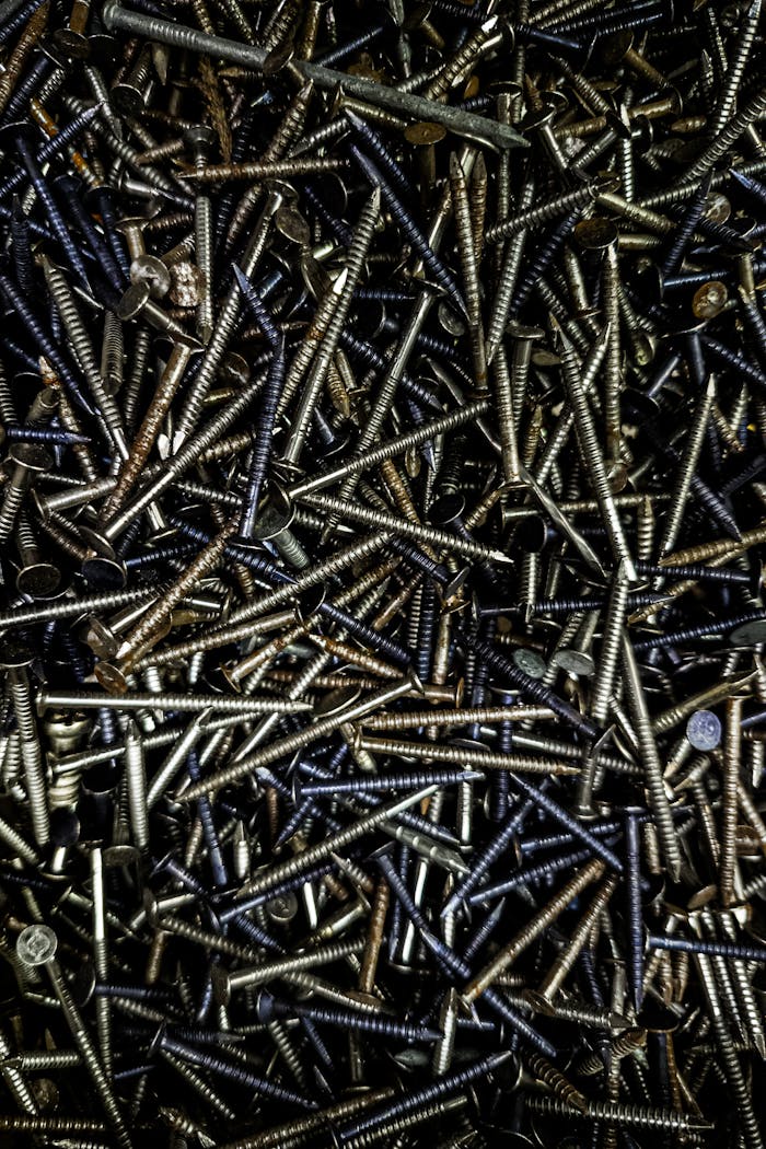 pexels-photo-29226820 Detailed top-down view of various metal screws showcasing industrial texture and metallic tones.